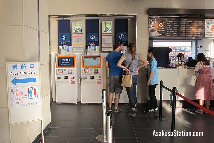 A member of staff assisting passengers at the ticket machines