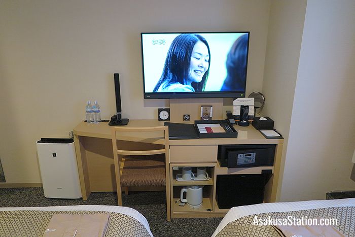 Guest room facilities include a desk with a reading lamp and chair