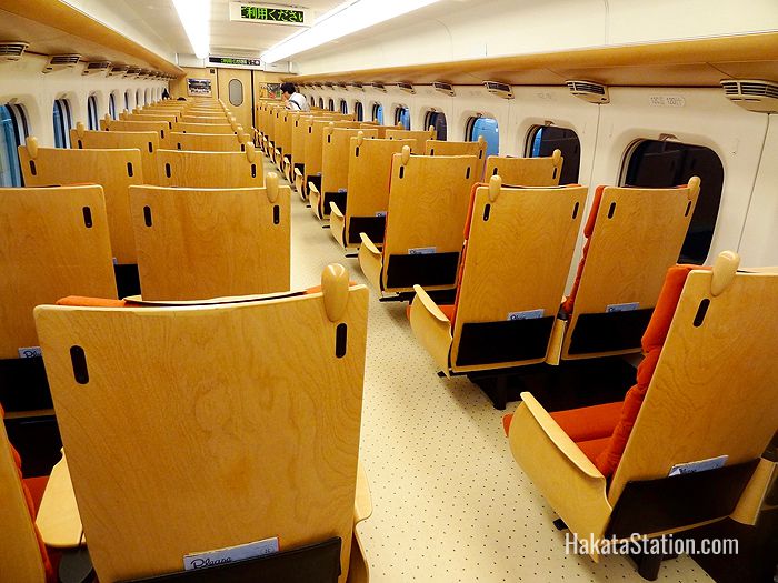 Interior design elements of the Kyushu Shinkansen include wooden-backed seats and gold-leaf paneling