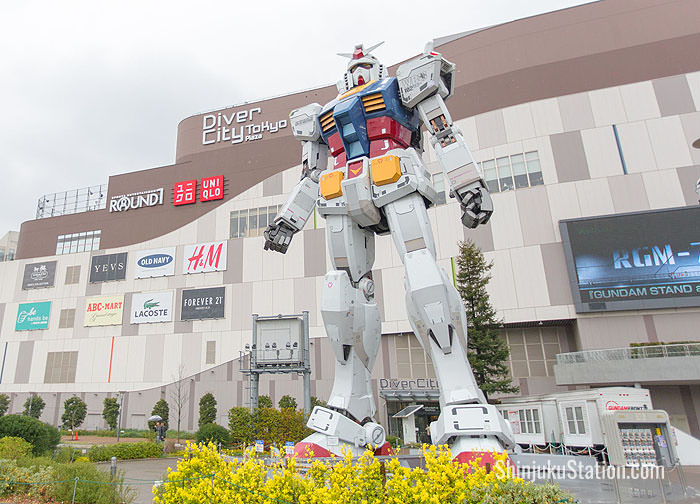 A statue of Gundam, the iconic robot from the anime franchise Mobile Suit Gundam towers over visitors in Odaiba