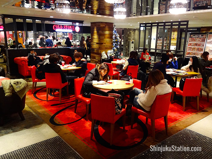 The eighth-floor dining area at Lumine Est features plush red sofas for relaxing