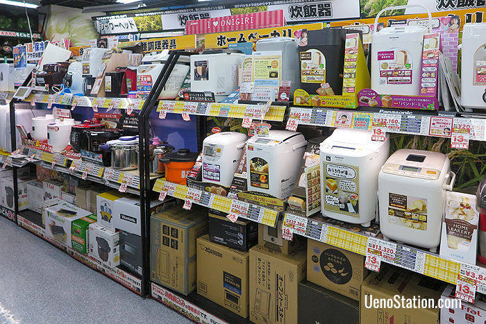 A display of rice cookers on the left and bread making machines on the right